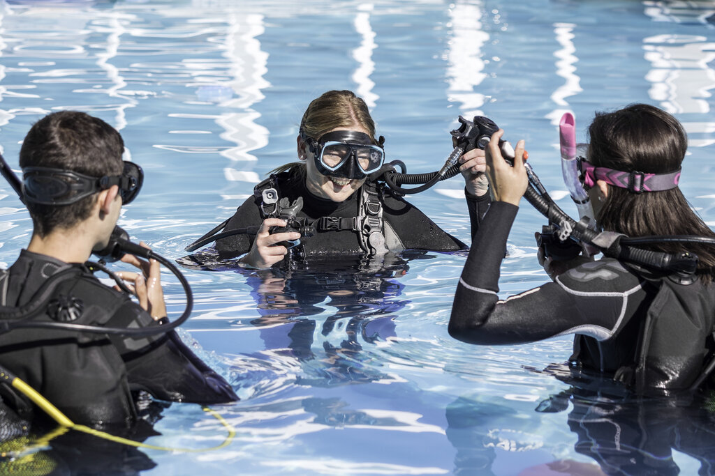 Instructora de buceo impartiendo clase en la piscina